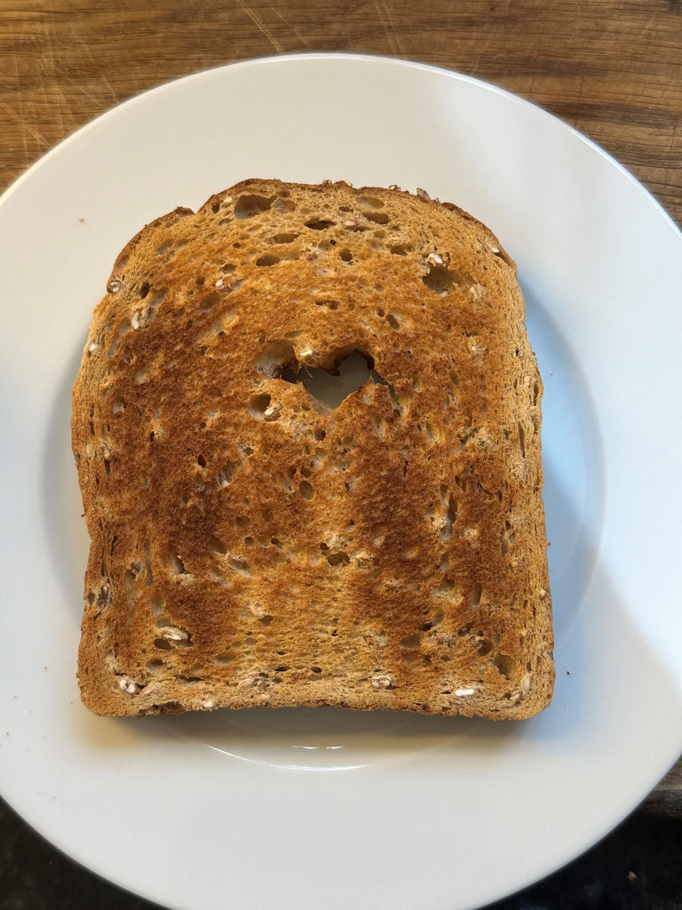 Piece of toast with heart-shaped hole in it.