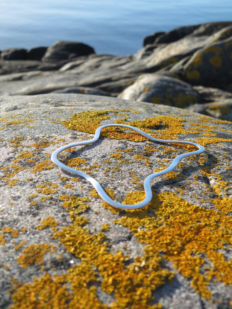 Furusund solid silver bracelet lying on on granite cliff, by Viveka Alvestrand Jewellery.